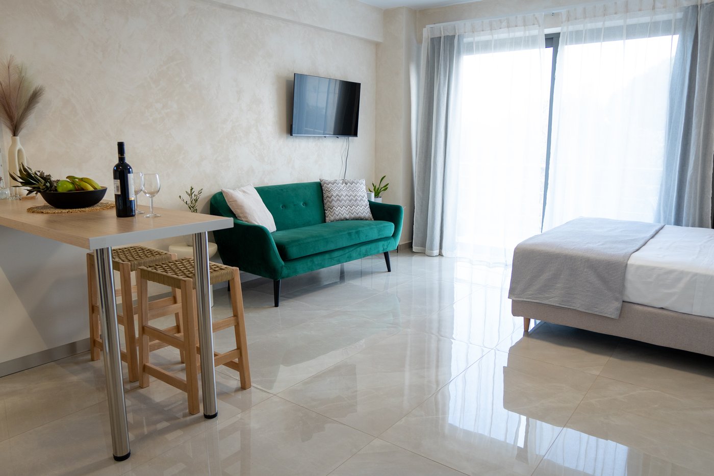 Bright studio interior with emerald sofa and dining nook